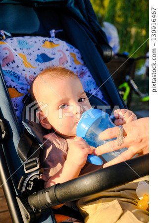 Baby in Stroller with Sippy Cup Outdoors Baby in Stroller with Sippy Cup Outdoors 130916467