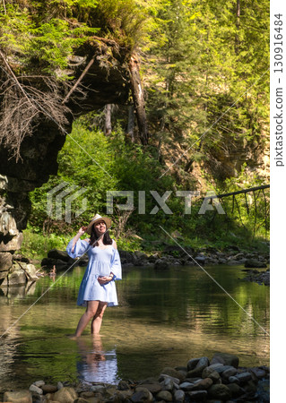 Woman Enjoying a Tranquil Forest Stream Woman Enjoying a Tranquil Forest Stream 130916484