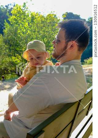 Father and Baby Relaxing in Sunny Park 130916512