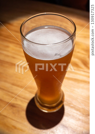 Enjoying a refreshing beer in a warm and inviting setting during 130917325