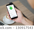 Closeup hand holding a smartphone. The phone show a payment form on its screen. 130917543