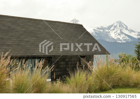 Cabin among tall grass and mountains in beautiful day Cabin among tall grass and mountains in beautiful day 130917565