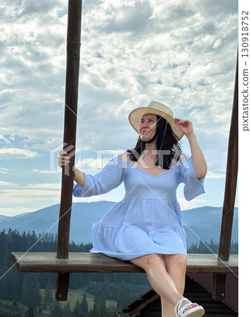 Woman Swinging Over Scenic Mountain Landscape Woman Swinging Over Scenic Mountain Landscape 130918752