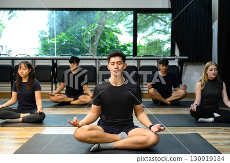 Relaxing yoga group focusing on breathing and inner peace indoors 130919184