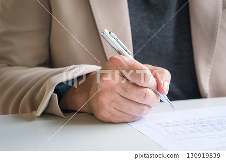 Businessman looking at document about to write or sign on it. Businessman looking at document about to write or sign on it. 130919839