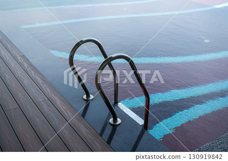 Grab bar ladder in swimming pool Grab bar ladder in swimming pool 130919842