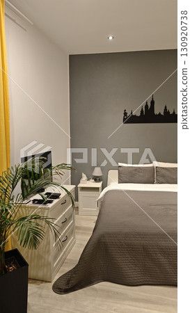Modern cozy bedroom with gray wall, white furniture and elegant decor. Concept of comfortable living space with minimalist interior design Modern cozy bedroom with gray wall, white furniture and elegant decor. Concept of comfortable living space with minimalist interior design 130920738