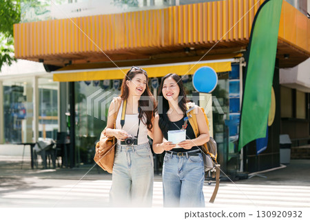 Cheerful Friends Walking in City with Map 130920932