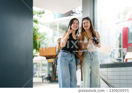 Exploring Together. Two young women smiling while planning their next adventure. Exploring Together. Two young women smiling while planning their next adventure. 130920935