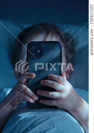 Child Using Smartphone in Bed at Night 130921205