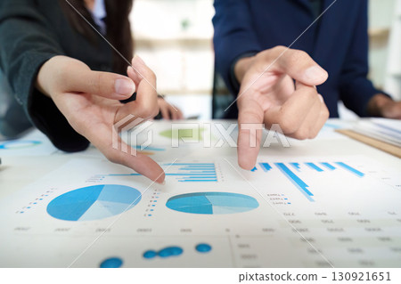 Business Analysis. Team members discussing financial data with charts and graphs. Business Analysis. Team members discussing financial data with charts and graphs. 130921651