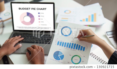 Budget Planning. Analyzing financial data with pie charts and graphs on a laptop. 130921715