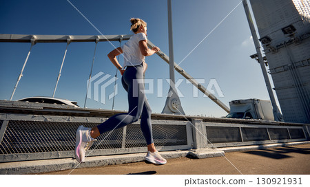 Active woman running on an urban bridge during a sunny day Active woman running on an urban bridge during a sunny day 130921931