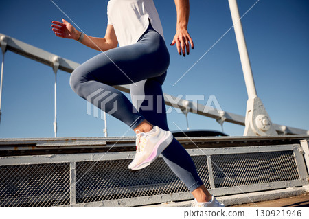 Athletic person in motion during an outdoor workout on a sunny day Athletic person in motion during an outdoor workout on a sunny day 130921946