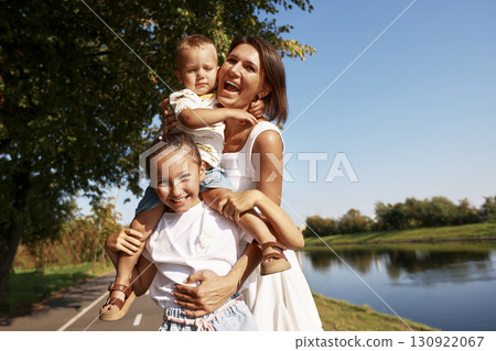 Happy mother with her children enjoying a day by the riverside 130922067