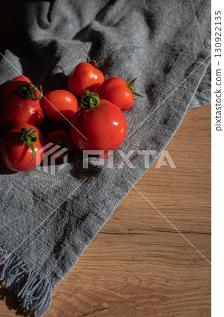 Red tomatoes on grey kitchen towel Red tomatoes on grey kitchen towel 130922135