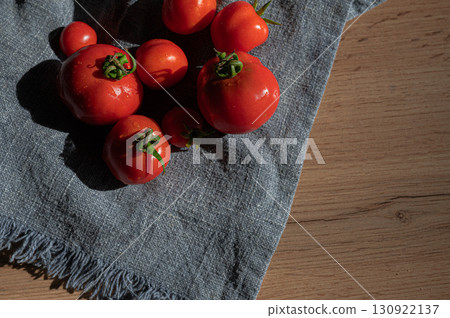 Red tomatoes on grey kitchen towel Red tomatoes on grey kitchen towel 130922137