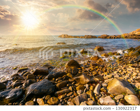 pebble coast at sunset under the rainbow. beautiful summer vacation season at the sea in evening light 130922317
