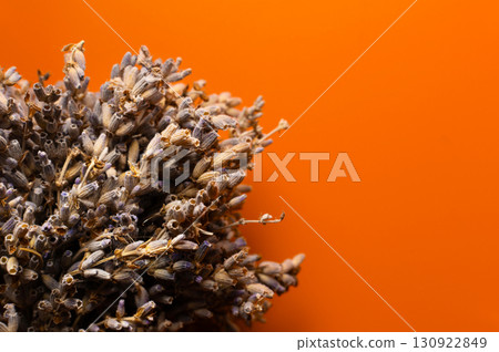 Bundles of dried lavender flowers tied with jute on the table. Small bouquet of dried lavender on orange background. Top view Bundles of dried lavender flowers tied with jute on the table. Small bouquet of dried lavender on orange background. Top view 130922849