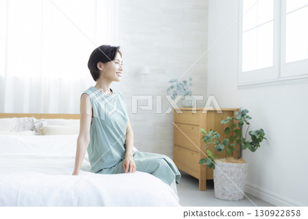 一個女人坐在床上 130922858