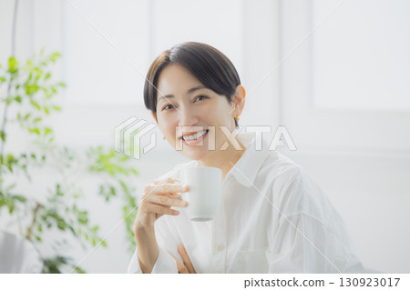 Middle woman drinking coffee in the living room 130923017