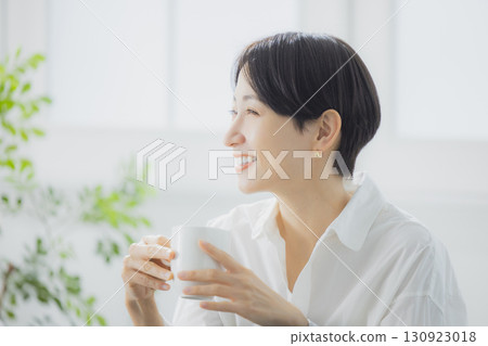 Middle woman drinking coffee in the living room 130923018