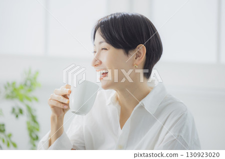 在客廳裡喝咖啡的中年女人 在客廳裡喝咖啡的中年女人 130923020