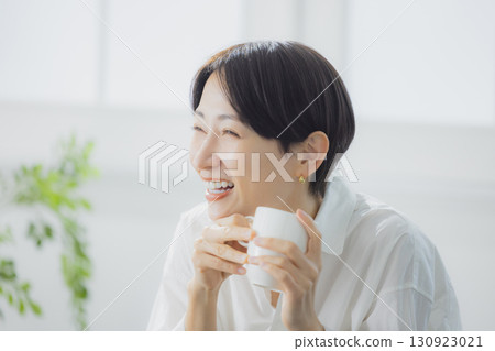 在客廳裡喝咖啡的中年女人 在客廳裡喝咖啡的中年女人 130923021