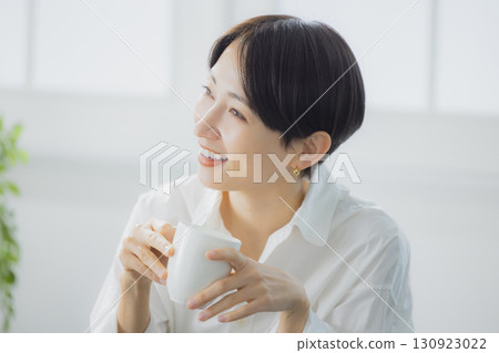 Middle woman drinking coffee in the living room Middle woman drinking coffee in the living room 130923022