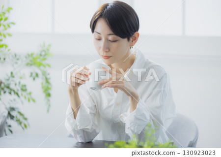 在客廳裡喝咖啡的中年女人 130923023