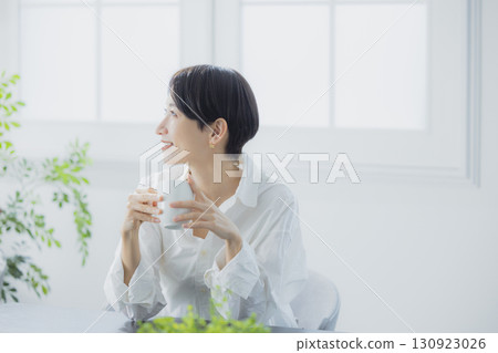 在客廳裡喝咖啡的中年女人 130923026