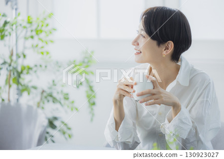 Middle woman drinking coffee in the living room 130923027