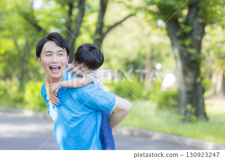 Parent and child playing in the park 130923247