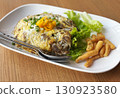 Stir-fried flat noodles with chicken, wrapped with egg. Close up Asian Thai-Chinese food menu on wooden table. 130923580