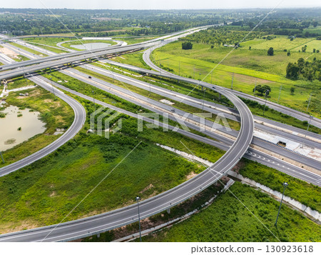 Drone shot a large highway interchange crossing over green farmlands in Thailand 130923618