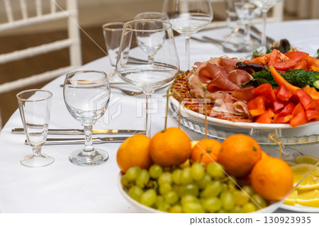 Platters with assorted meats and fruits on a festive table 130923935