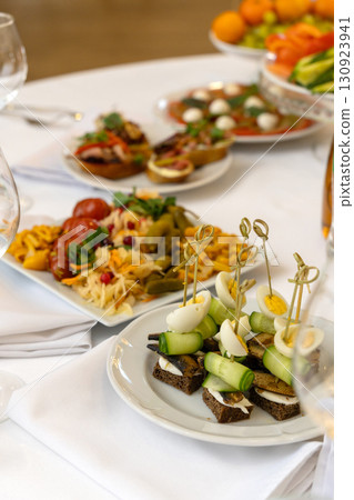A beautifully arranged plate of assorted bruschetta, canapes, and marinated appetizers 130923941