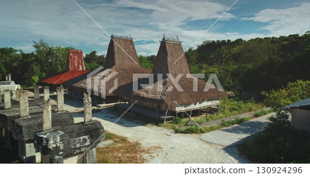 Aerial view capturing traditional Sumbanese houses with thatched roofs and ancient megalithic tombs in a rural village on Sumba Island, Indonesia, highlighting unique cultural heritage 130924296