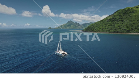 Fiji, Kuata island: White catamaran sailing through calm blue ocean water near green mountains tropical island, captured in stunning aerial . Remote wild nature paradise, exotic summer travel Fiji, Kuata island: White catamaran sailing through calm blue ocean water near green mountains tropical island, captured in stunning aerial . Remote wild nature paradise, exotic summer travel 130924303