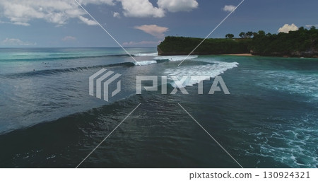 Perfect waves rolling towards Dreamland Beach in Bali, Indonesia, create a breathtaking scene as surfers eagerly wait for the ideal moment to ride 130924321