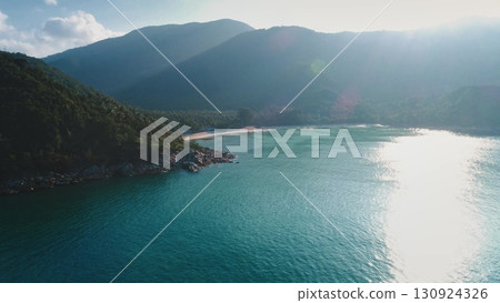 Sun shining on the turquoise waters of Bottle Beach, Koh Phangan, Thailand, creates a mesmerizing display of nature's beauty from a captivating drone perspective. Travel, tourism, holiday landscape 130924326