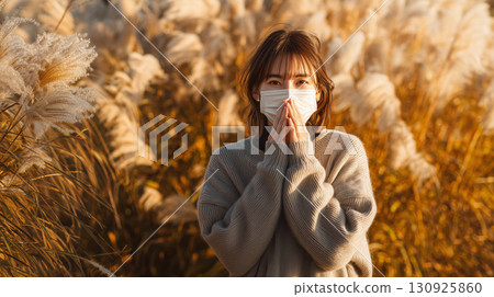 秋風中搖曳的蒲葦和戴著口罩的女子 130925860
