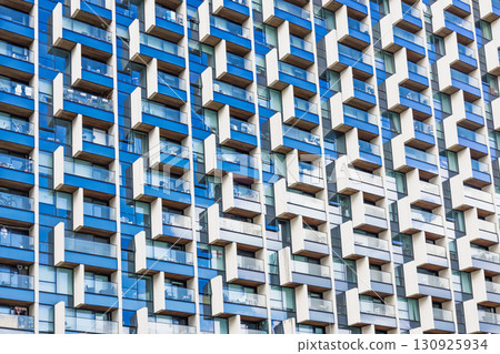 Modern apartment facade with repetitive balconies and windows pattern 130925934