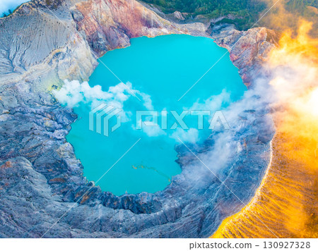 Aerial view of rock cliff at Kawah Ijen volcano with turquoise sulfur water lake at sunrise.Amazing nature landscape view at East Java, Indonesia. Natural landscape background Aerial view of rock cliff at Kawah Ijen volcano with turquoise sulfur water lake at sunrise.Amazing nature landscape view at East Java, Indonesia. Natural landscape background 130927328