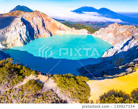 Aerial view of rock cliff at Kawah Ijen volcano with turquoise sulfur water lake at sunrise.Amazing nature landscape view at East Java, Indonesia. Natural landscape background Aerial view of rock cliff at Kawah Ijen volcano with turquoise sulfur water lake at sunrise.Amazing nature landscape view at East Java, Indonesia. Natural landscape background 130927334