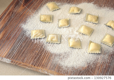 Homemade ravioli with fish and cuttlefish ink on wooden board. Traditional food, Italy. Healthy eating and organic products. 130927576
