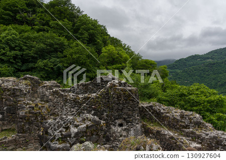 The ruined wall of the fortress of Gvara, Georgia, mountains, clouds The ruined wall of the fortress of Gvara, Georgia, mountains, clouds 130927604