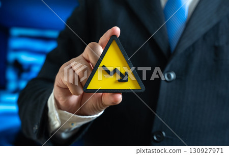 A symbol of falling income in the hands of a businessman. Crisis and financial problems. Staff reduction and decreased investment activity. Symbol of economic downturn, instability, risks 130927971