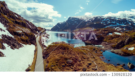 Mountain landscape in summer. Aerial view at glacier melted lake, mountains ridge, and highway. Nature park in Sauda municipality, Rogaland fylke. Beautiful nature of Norway Mountain landscape in summer. Aerial view at glacier melted lake, mountains ridge, and highway. Nature park in Sauda municipality, Rogaland fylke. Beautiful nature of Norway 130928120