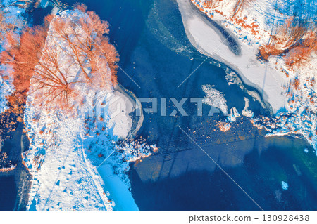 Aerial view of a narrow river on a sunny day in a snowy winter 130928438